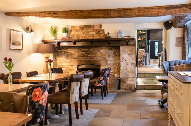 A dining room at The Fleece next to a fireplace