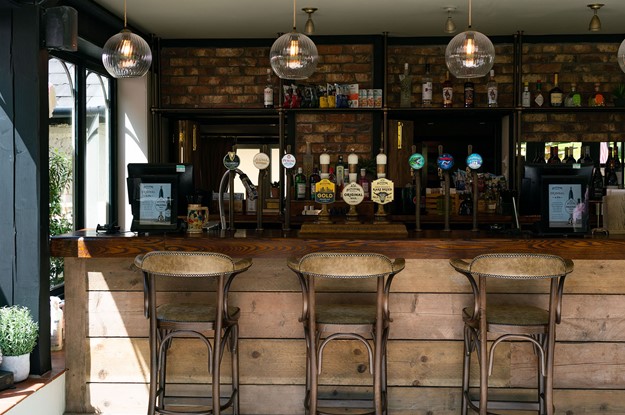 external wooden bar with barstools and butcombe ales